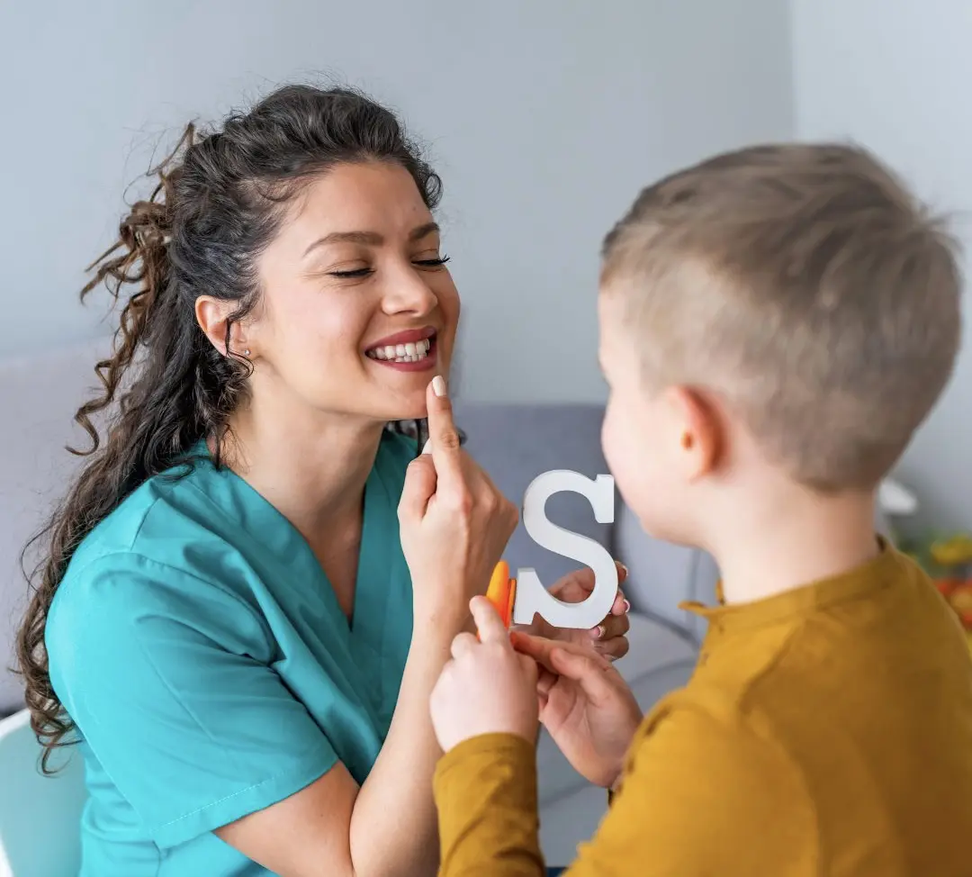 A woman and boy holding up the letter s.